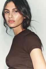 Camiseta de manga corta y cuello redondo, color crema, con tejido acanalado (rib) y corte ajustado (slim fit).