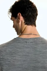 Remera deportiva gris melange con tecnología DryMove™, de manga corta y cuello redondo, diseñada con tejido de malla transpirable y elástico para entrenar.