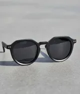 Lentes de sol Achawen All Black con montura geométrica en relieve y lentes polarizadas negras.