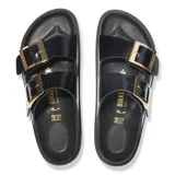 Sandalias Birkenstock Arizona modelo Droplet Buckle, color negro con dos correas anchas y grandes hebillas doradas. Presenta plantilla anatómica de corcho y suela de EVA negra.