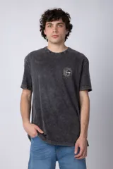 Remera de algodón con efecto de lavado desgastado tipo snow wash, de corte semi-oversize, cuello redondo y manga corta. Presenta un pequeño estampado gráfico circular en el pecho.