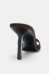 Sandalia tipo mule de tacón alto fino, color marrón oscuro, con capellada de serraje y punta cuadrada.