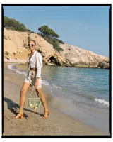 Camisa crop color blanco, de seda, con mangas largas abullonadas y cuello en V. Presenta detalle de punto smock en el frente y cierre con lazo.