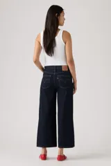 Jean de denim azul oscuro con corte wide leg y diseño cropped al tobillo, con tiro medio y costuras en contraste.