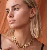 Earcuff de metal plateado, diseño orgánico y texturizado, que se ajusta al cartílago de la oreja sin necesidad de perforación.