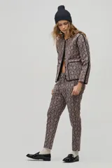 Pantalón de corte jogger con cintura elástica y cordón ajustable, confeccionado en jacquard con estampado damasco beige y negro.