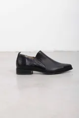 Botín de cuero natural negro con terminación lisa en la parte delantera, lateral con textura metalizada y talón con estampado texturado tipo reptil. Cuenta con calce slip-on y suela baja con tacón cuadrado.