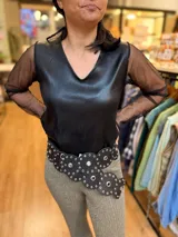 Top negro de eco cuero con cuello en V y mangas largas de microtul transparente.