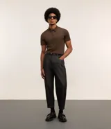 Camisa polo masculina de manga corta, confeccionada en tejido técnico de poliamida con elastano. Presenta cuello inglés con cierre de botones y diseño liso en color marrón, con tecnología de secado rápido y confort térmico.