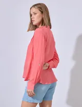 Blusa color salmón de gasa marca Zac & Rachel, con cuello a la base, escote en V, botones y detalle plisado en la parte delantera. Mangas largas regulables con presilla y botón.