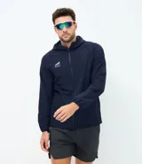 Chaqueta deportiva masculina de color azul marino, confeccionada en tejido técnico repelente al agua con acabado texturizado. Presenta cierre frontal con cremallera, capucha integrada y estampado de coordenadas en el pecho.