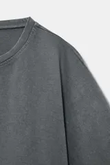 Top crop de algodón con efecto lavado, cuello redondo y mangas cortas holgadas de tipo capa.