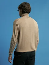 Polera de punto de manga larga en color azul marino, con cuello alto doblado y puños y ruedo acanalados.