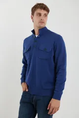 Sweater azul con cuello alto abotonado y dos bolsillos frontales con botón.