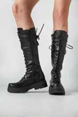 Borcegos negros de ecocuero con cordones y hebilla lateral.