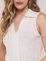 Musculosa tejida de marca Elie Tahari, color blanco, con cuello con solapa y escote V pronunciado, confeccionada en tejido de punto calado con patrón geométrico.