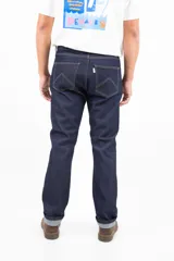 Jean clásico de corte recto, cinco bolsillos, color azul oscuro. Confeccionado en denim de 14 onzas sin elastano, con botones de cobre y costuras color camel.