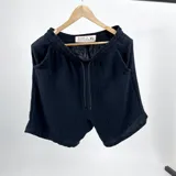 Bermuda short negra de muselina con bolsillos delanteros y traseros. Corte vestir.