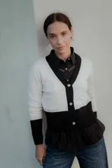 Saco tipo cardigan bicolor con diseño de bloques en blanco y negro, cuello en V, cierre frontal con botones y mangas largas con puños ajustados.