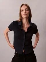 Chomba Calvin Klein de manga corta en color azul marino, con diseño de jacquard geométrico integral, cuello clásico y cierre frontal completo de botones.