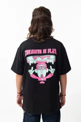 Remera negra de algodón con estampado en la espalda que dice "THE EARTH IS FLAT" y un dibujo de un hombre con micrófono parado sobre una tierra plana.