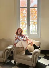 Sweater de punto con diseño geométrico en tonos celeste, marrón y beige.