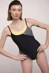 Malla enteriza combinada en colores negro y amarillo, con diseño de doble tirante y paneles laterales con estampado geométrico de rayas en blanco y negro.