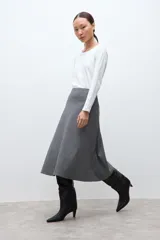 Falda midi de corte acampanado con estampado de cuadros pequeños en tonos grises. Presenta un diseño de tiro alto y estructura firme.