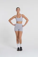 Minishort deportivo gris con cintura alta y recortes laterales blancos.