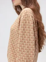 Sweater de tejido de punto jacquard con diseño geométrico, cuello redondo y puños acanalados en contraste de color verde y beige.