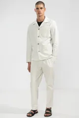 Pantalón de algodón color crema con textura seersucker, corte recto, bolsillos laterales y traseros, cierre con botón y cremallera.