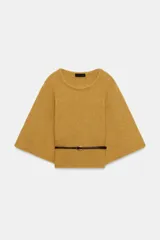Jersey de punto color mostaza con cuello redondo y mangas amplias tipo murciélago. Presenta un diseño ajustado en la cintura con un cinturón fino de cuero sintético en color marrón a contraste.