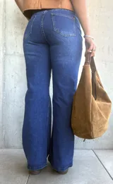 Jean de corte recto y tiro alto en color azul lavado, con costuras verticales decorativas en el frente y cierre frontal con botón metálico.