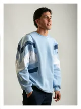 Buzo de algodón con diseño inspirado en la indumentaria deportiva uruguaya de 1995. Presenta un diseño de bloques de color con franjas diagonales en contraste, cuello redondo y bordado en el pecho. Cuenta con puños y cintura acanalados.