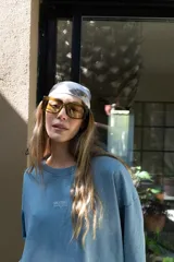 Lentes de sol con montura gruesa de forma cuadrada/rectangular, color verde oliva translúcido, y cristales tintados en tono ámbar/marrón claro.