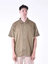 Camisa verde militar de manga corta con cuello clásico y cierre frontal con botones.