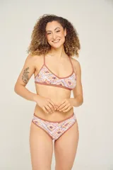 Corpiño de bikini con estampado geométrico en tonos lila, verde y blanco, con breteles finos cruzados en la espalda.