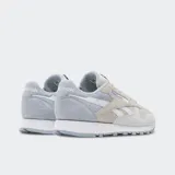 Championes Reebok Classic Leather en tonos gris, beige y blanco, con capellada de cuero y gamuza, forro textil, entresuela de EVA y suela de goma.