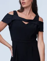 Enterito largo negro de seda fría, marca RM Richards. Presenta escote asimétrico y mangas cortas con detalle de brillos. Espalda con abertura central y cierre invisible.