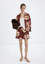 Short marrón con estampado floral grande en tonos beige y blanco, de tiro regular y silueta relajada con cintura elástica.