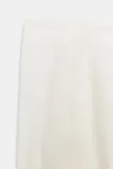 Pantalón de tiro medio confeccionado en una mezcla de lino y algodón. Presenta un diseño de corte recto con trabillas en la cintura, bolsillos laterales y cierre frontal con cremallera, botón y ganchos metálicos.