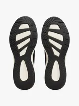 Zapatillas deportivas negras de corte bajo y estilo calcetín, con exterior de punto elástico. Cuentan con cordones, entresuela gruesa color crema y suela de goma negra. Presentan un pequeño logo de Tommy Hilfiger bordado en el lateral.