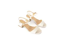 Sandalia de cuero color blanco con taco cuadrado de 5 cm, tira delantera y pulsera ajustable al tobillo con hebilla metálica.