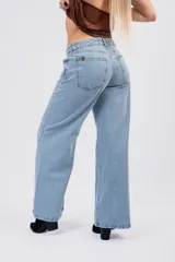 Jean de corte wide leg y tiro bajo, en color celeste clásico con acabado lavado. Presenta diseño de cinco bolsillos, cierre frontal con botón y cremallera, y pernera ancha de caída fluida.