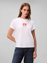 Remera Calvin Klein de algodón color blanco, con cuello redondo, mangas cortas y estampa frontal cuadrada con el monograma cK en tonos degradados de rojo y rosado.