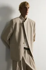 Blazer de corte relaxed fit confeccionado en tejido de lino y algodón de origen italiano. Presenta cuello mao, cierre cruzado con botones, bolsillos de vivo en la cadera y manga larga.