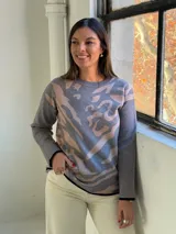Sweater de punto con diseño estampado abstracto en tonos gris y beige, cuello redondo y terminaciones en color negro.