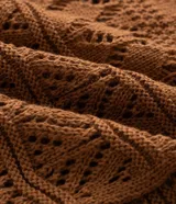 Saco corto de tricot marrón con diseño de puntos calados, escote en V, mangas largas y cierre frontal con lazo ajustable.