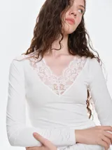 Remera de dormir entallada de viscosa, color bordó, con escote en V profundo adornado con encaje al tono y mangas largas.