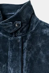 Cazadora estilo bomber confeccionada en piel, con cuello solapa, manga larga y cierre frontal con cremallera oculta y botones a presión. Presenta bolsillos delanteros de plastrón con solapa y botón a presión.